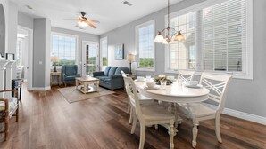 A spacious living room with a dining area, large windows, and a ceiling fan. - The Golden Hour Great Views (Branson)