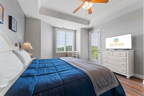 A bedroom with a bed, a ceiling fan, a TV, a dresser, and a window. - The Golden Hour Great Views (Branson)