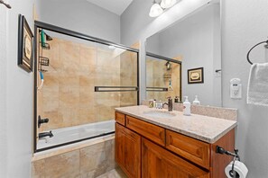 A bathroom with a glass shower enclosure, wooden vanity, and a large mirror. - The Golden Hour Great Views (Branson)