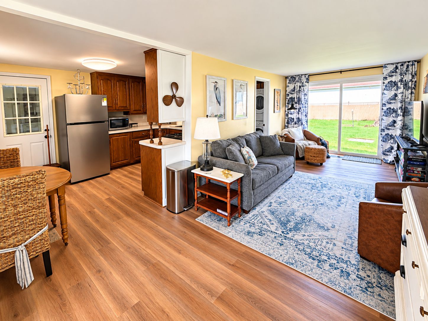 A modern kitchen with wooden cabinets, a stainless steel refrigerator, and a microwave.