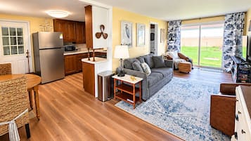 A modern kitchen with wooden cabinets, a stainless steel refrigerator, and a microwave.