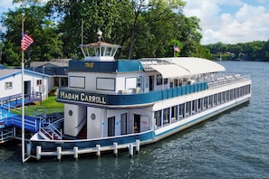 A riverboat named 'Madam Carroll' docked at a pier with a covered deck and a small building adjacent to it. - Cozy cottage with Lake Freeman access, within walking distance to Madam Carroll (Monticello)