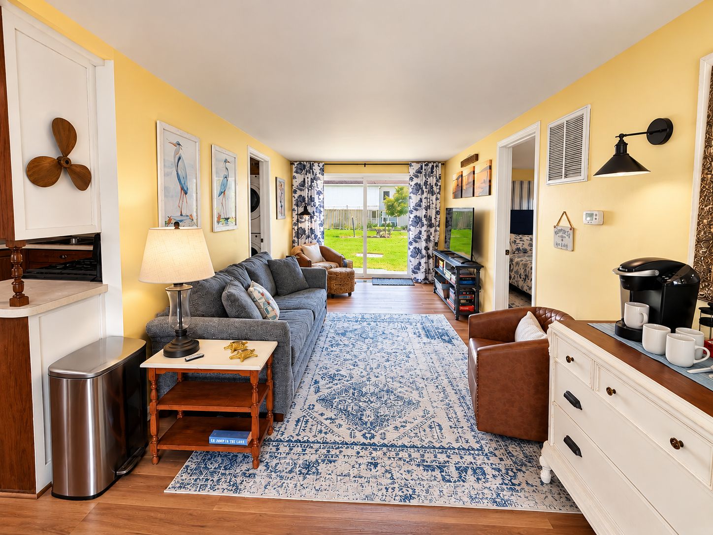 A compact living space with a sofa, coffee table, and a view of the outdoors.