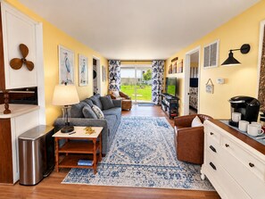 A compact living space with a sofa, coffee table, and a view of the outdoors. - Cozy cottage with Lake Freeman access, within walking distance to Madam Carroll (Monticello)