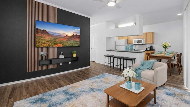A modern living room with a large TV, a dining area, and a kitchen. - Scottsdale Oasis Retreat  Pool, BBQ, EV Parking (Scottsdale)