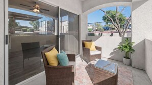 A balcony with wicker furniture, a ceiling fan, and a potted plant. - Scottsdale Oasis Retreat  Pool, BBQ, EV Parking (Scottsdale)
