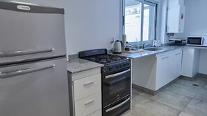 A modern kitchen with a refrigerator, stove, oven, and microwave.