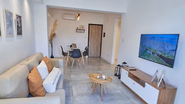 A modern living room with a sofa, coffee table, and TV.