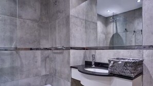 A modern bathroom with a bathtub, a sink with a mirror, and a shower area.