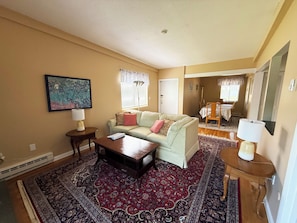 A living room with a sofa, coffee table, and a rug.
