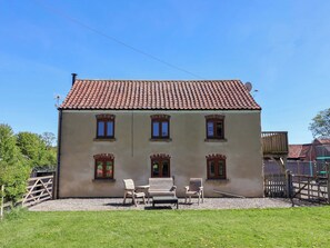 A two-story building with a tiled roof, multiple windows, and a gravel driveway. - The Granary (York)