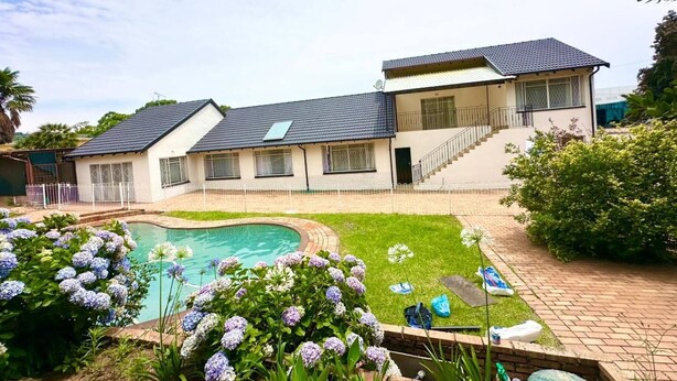 A two-story house with a swimming pool, a covered patio, and a well-maintained garden. - Crest Premiums Sandton (Johannesburg)