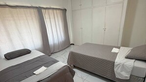 A bedroom with two beds, a wardrobe, and a ceiling light. - Crest Premiums Sandton (Johannesburg)
