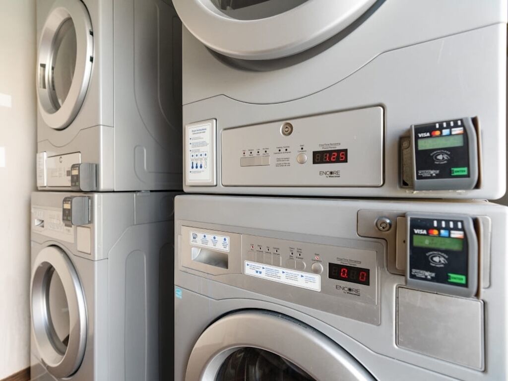 Una pila de lavadoras modernas y compactas con pantallas digitales y paneles de control.