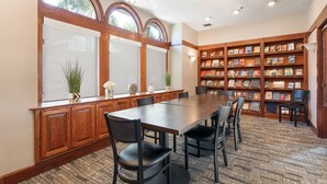 A conference room with a long table, chairs, a wooden cabinet, a bookshelf, and a window with a view of trees. - 3 Units: Pet-Friendly Kitchen Suite 2 mi to Carbon Canyon Regional Park (Brea)
