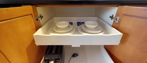Una cocina con encimera integrada, dos cuencos, un tostador y un enchufe.
