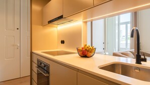 Uma cozinha moderna com uma ilha grande, pia dupla e forno embutido.
