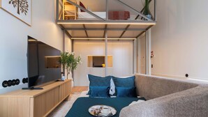 Quarto moderno com cama, televisão, escrivaninha e varanda.