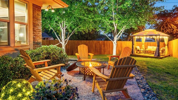 Une terrasse avec des meubles d’extérieur, un foyer et un espace salon abrité.
