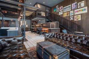 Ein modernes Interieur mit Ledersofas, einer Treppe und Kunstwerken an den Wänden.