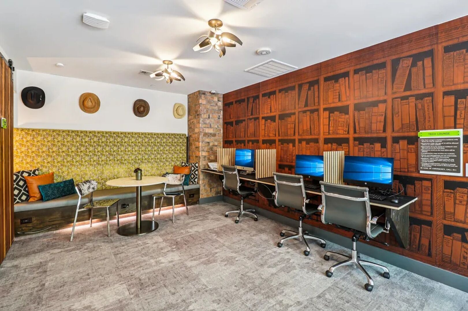A library with bookshelves, a round table, and multiple computer stations.