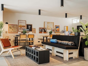 A modern living room with a sofa, chairs, a coffee table, and artwork on the walls. - King+Queen Bunk | Joshua Tree | Trundle Space, Pool, Fire Pit (Yucca Valley)