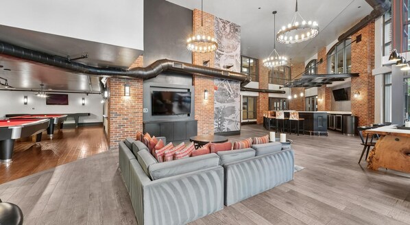 A modern interior with a pool table, seating area, bar, and entertainment system. - Landing | Chic 1BD, Courtyard, Gym (Washington)