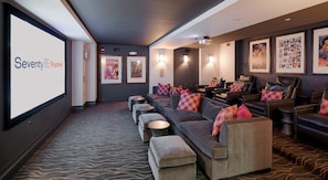 A theater room with a large screen, multiple seating rows, and framed pictures on the walls. - Landing | Chic 1BD, Courtyard, Gym (Washington)