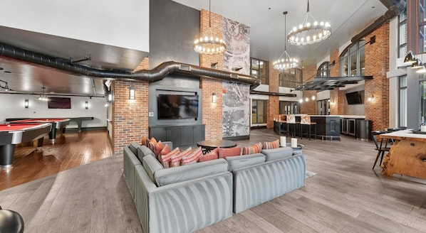 A modern interior with a pool table, seating area, bar, and entertainment system. - Landing | Incredible 1BD, Courtyard, Gym (Washington)