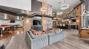 Ein modernes Interieur mit Billardtisch, Sitzecke, Bar und Unterhaltungssystem.