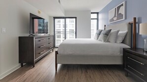 Ein Schlafzimmer mit Bett, Kommode und Fernseher.