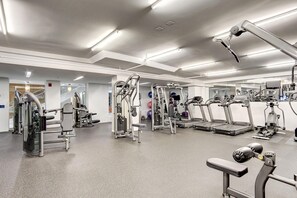 Ein modernes Fitnessstudio mit diversen Trainingsgeräten, einem großen Spiegel und einem sauberen, gut beleuchteten Raum.