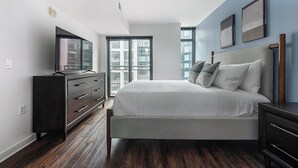 Ein Schlafzimmer mit Bett, Kommode und Fernseher.