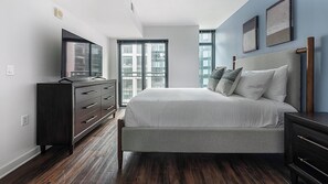 A bedroom with a bed, dresser, and TV. - Landing | Amazing 2BD, Courtyard (Washington)