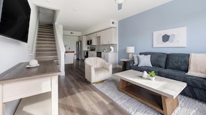 A modern living room with a sofa, coffee table, and a TV. - Landing | Incredible 1BD, Clubhouse (Austin)