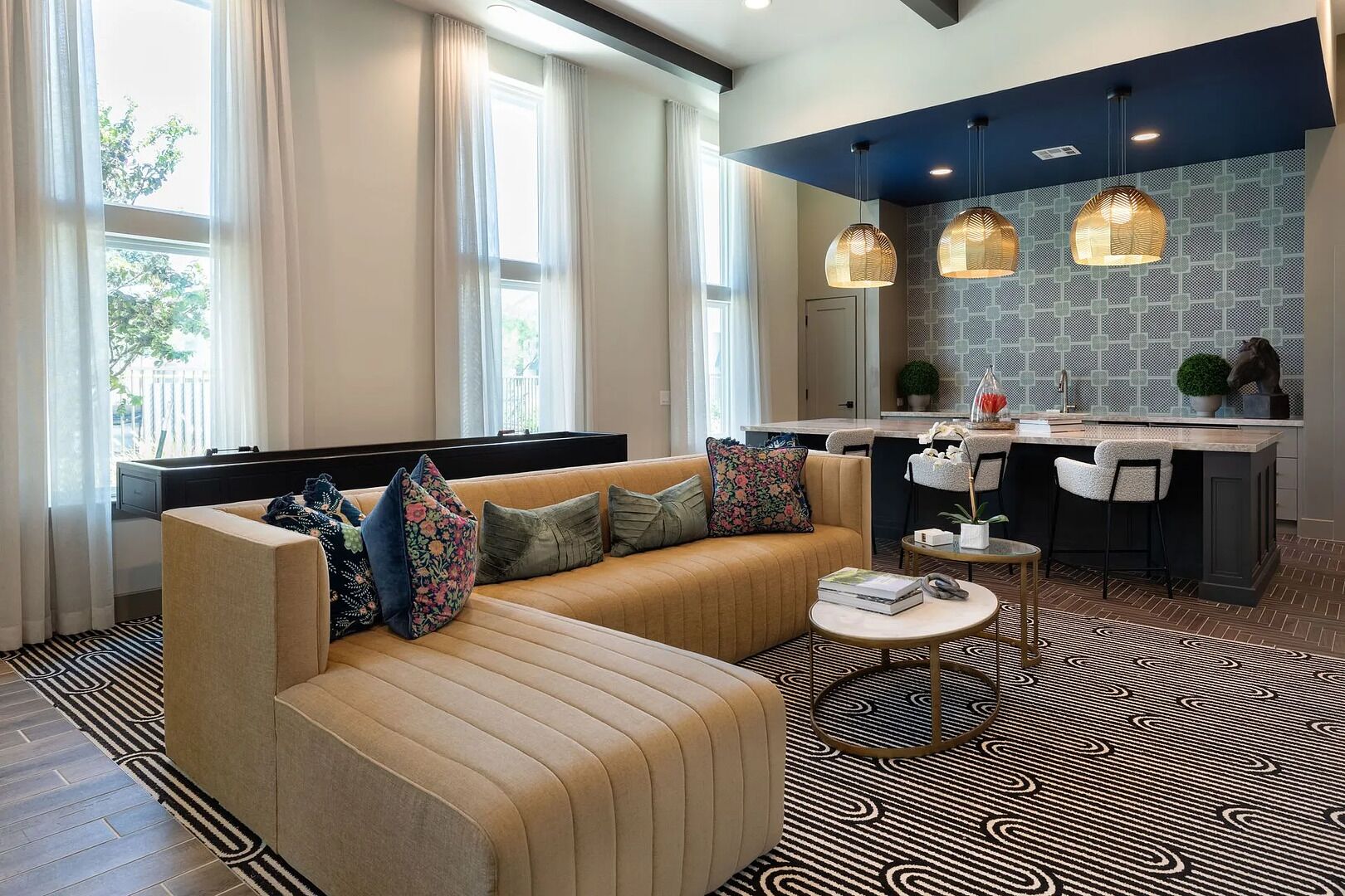 A modern living room with a sofa, a coffee table, and a kitchen area with a bar.
