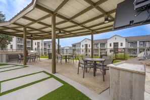 Ein Außenbereich mit Terrassensitzgruppe, Grill und Billardtisch.