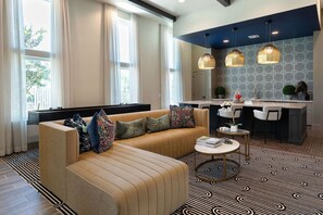 Ein modernes Wohnzimmer mit einer Couch, einem Couchtisch und einer Küchenzeile mit Bar.