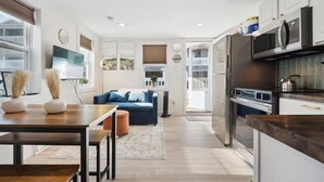 Une cuisine moderne avec un coin repas, un canapé et un téléviseur.