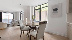 Un salon spacieux avec un coin repas, de grandes fenêtres et un design moderne.