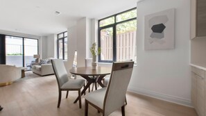 Ein geräumiges Wohnzimmer mit Essbereich, großen Fenstern und modernem Design.