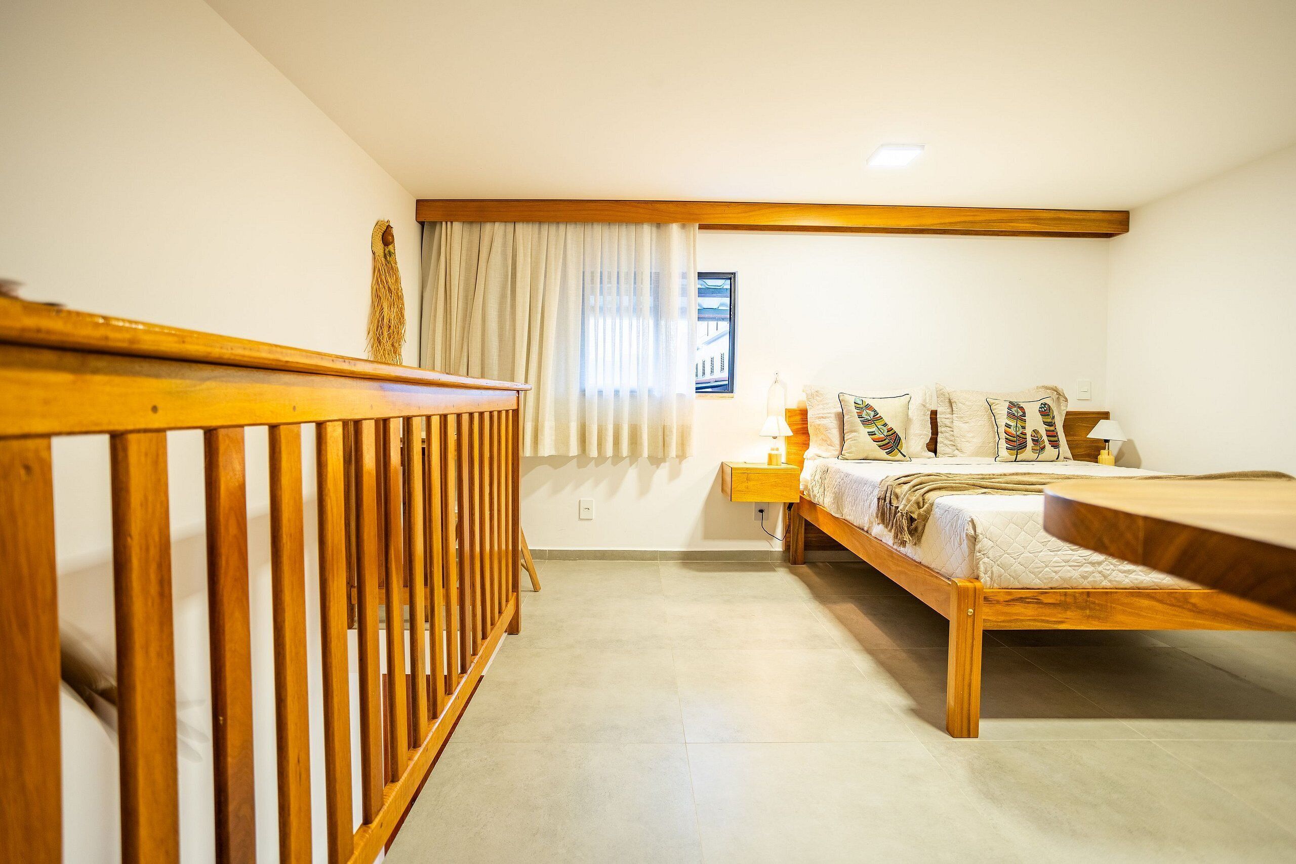 A bedroom with a wooden bed, a nightstand, and a window with curtains.