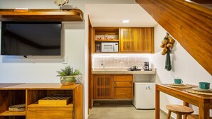 A compact kitchen with wooden cabinets, a microwave, a coffee maker, and a small refrigerator. - Arara House 1 (Jijoca de Jericoacoara)