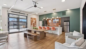 Una cocina moderna con una isla central, un área de comedor con banco y un espacio de estar con sofá.