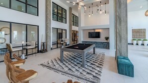 A spacious living area with a pool table, seating, and a TV. - Landing | Beautiful 1BD, Gym, Yoga Studio (Pooler)