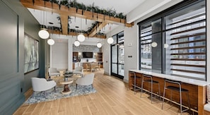 A modern interior with a dining area, bar, and kitchen. - Landing | Spectacular 2BD, Courtyard, Yoga Studio (Nashville)