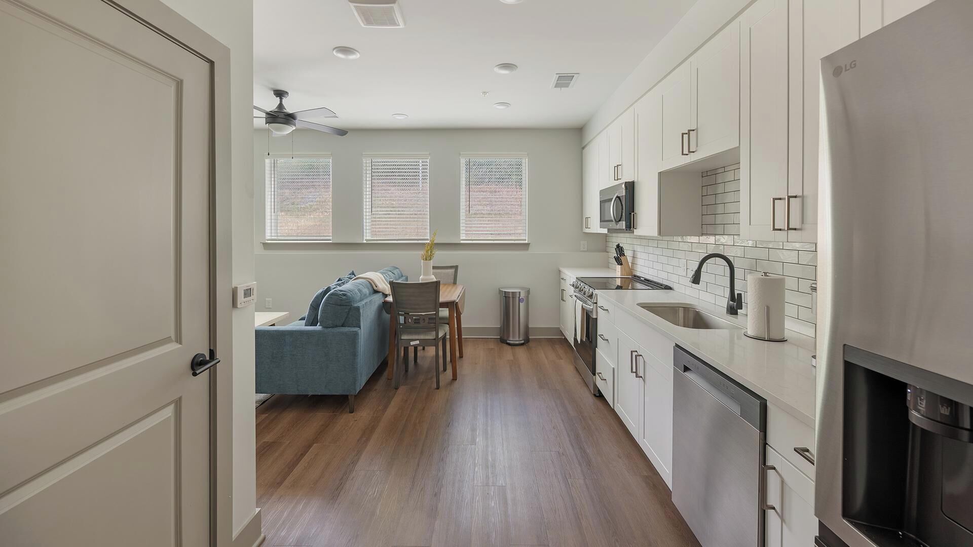 A modern kitchen with white cabinets, a microwave, and a dishwasher.