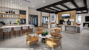 Uma sala de estar ampla com cozinha, área de jantar e assentos, incluindo uma lareira.