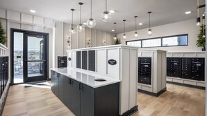 A modern hotel lobby with a reception desk, a glass door entrance, and a view of the outside. - Landing | Incredible 1BD, Yoga Studio, Clubhouse (Broomfield)