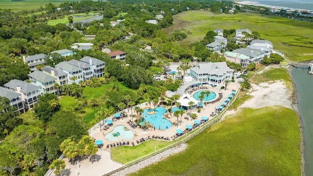 Een resort met meerdere gebouwen, een groot centraal zwembad en direct toegang tot het strand.